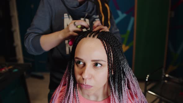 A Female Stylist Attaches Senegalese Braids to a Woman in a Beauty Salon