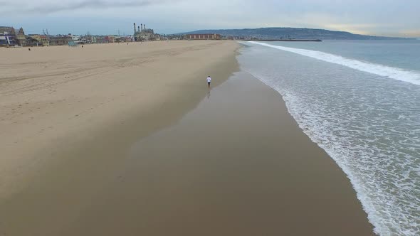 Aerial shot of young man running on the beach.