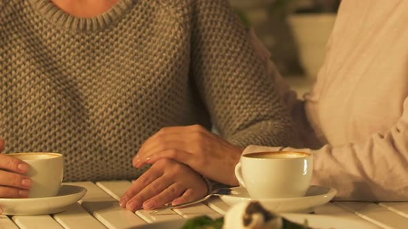 Woman Stroking Friend Hand in Support, Two Sisters Experiencing Grief Together