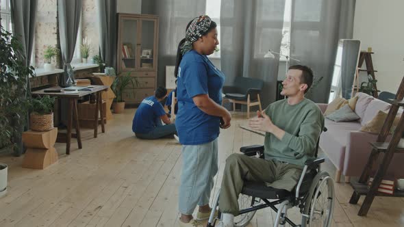 Man in Wheelchair and Female Volunteer Hugging