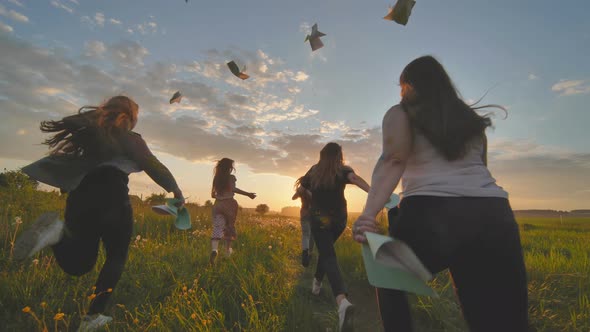 Cheerful Students Run Throwing Notebooks After School at Sunset