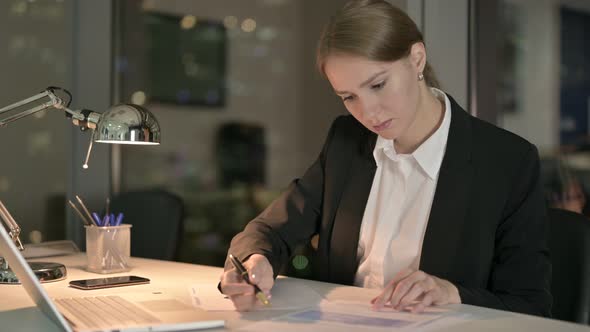 Ambitious Businesswoman Doing Writing Documents at Night 