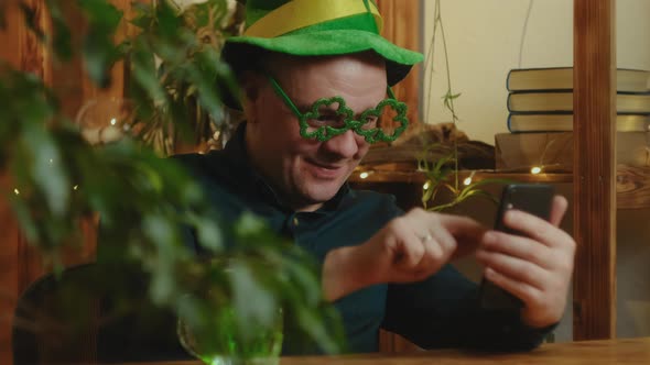Man Celebrating Saint Patricks Day Using Smartphone at Home