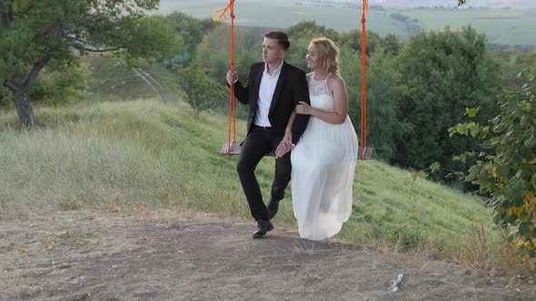 Bride and groom relaxing on a swing