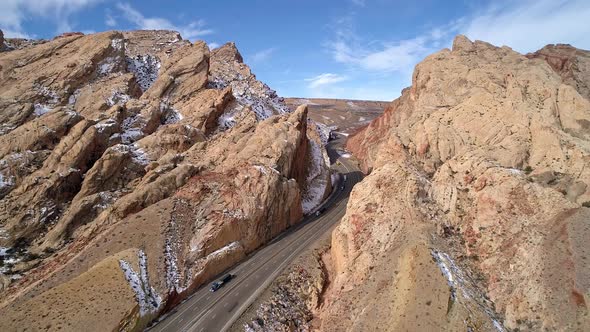 Aerial view of truck convoy driving through gorge on freeway