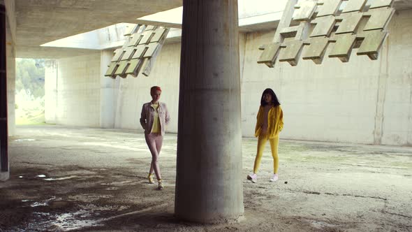 Two fashionable women walking in an abandoned building