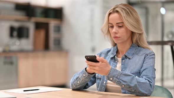 Attractive Young Woman Using Smartphone at Work