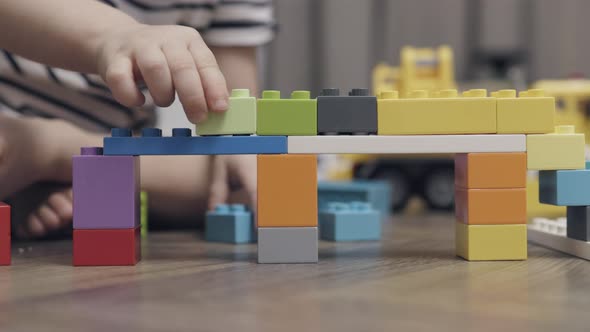 Unrecognizable Child Kid Hands Playing Colorful Plastic Building Blocks Indoors