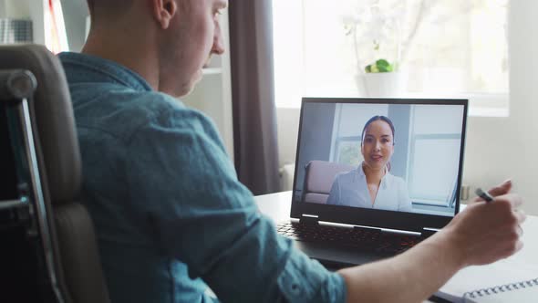 Young male entrepreneur works at home office at the computer.