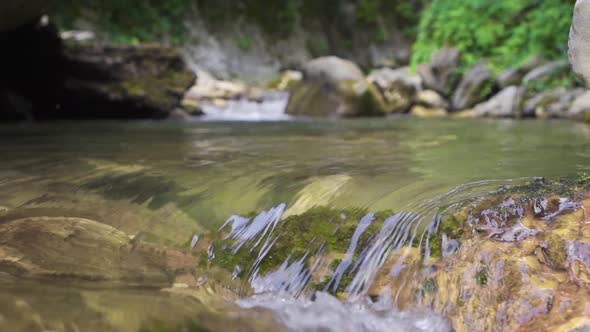 Clean water flowing in the stream. Slow motion.