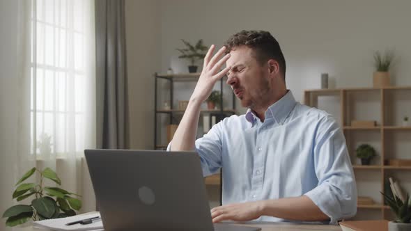 Badtempered Man Sit at Desk Stressing Out While Work on Laptop Having Difficulties with Device