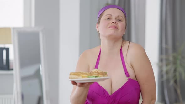 Confident Obese Caucasian Woman Posing with Unhealthy Junk Food Indoors