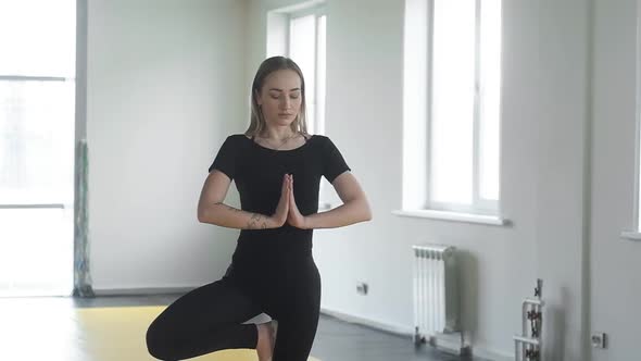 Yoga girl student in Studio. a woman meditates in a balance pose in yoga Studio