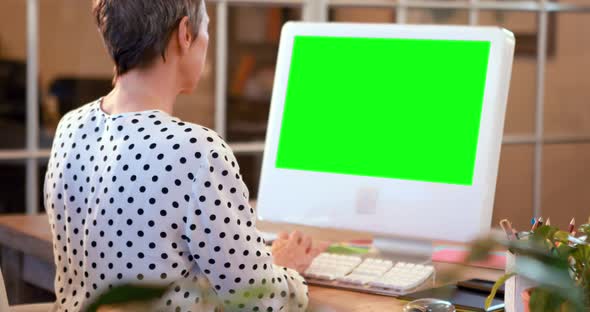 Casual businesswoman using computer with green screen