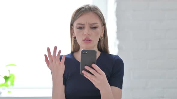 Portrait of Woman Reacting to Loss on Smartphone