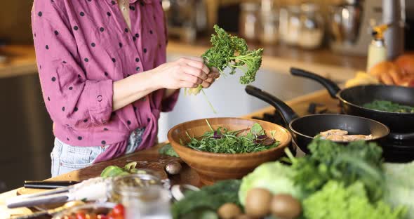 Woman Making Salad in Wooden Bowl Closeup