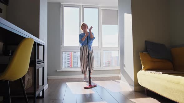 The Girl Sings a Song on the Balcony and Washes the Floor