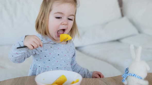 Adorable One and Half Years Old Girl Eating Mango Pieces