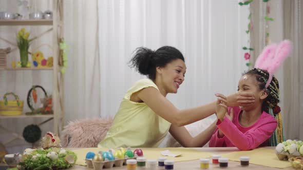 Mom and Daughter with Funny Bunny Ears Stick Picture Stickers on Each Other's Faces and Laugh