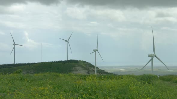 Wind Turbine Propellers Spinning in Wind, Windmills in Beautiful Green Field