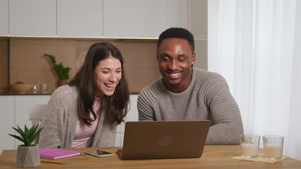 A Couple Having an Online Conference Video Call with Their Friends at Their Apartment Kitchen