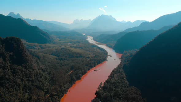 Aerial: flying over Nam Ou River Nong Khiaw Muang Ngoi Laos, sunset dramatic sky