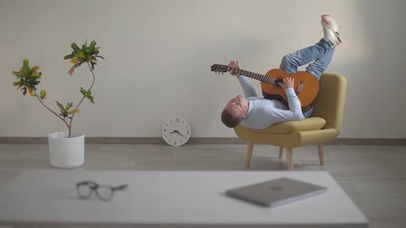 a Man in the Office Playing a Guitar