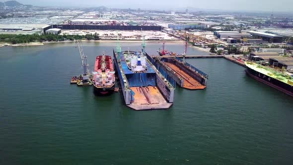 Aerial view of logistics concept a cargo ship being retrofit, repair and services on a floating dry