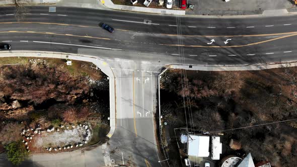 Aerial flyover sleepy small town roads with cars driving, looking down.