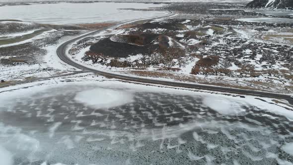 Aerial View of Frozen Lake, Road and Volcanic Crater in Highlands of Iceland.