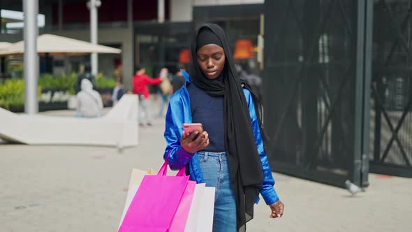 Muslim Woman Using Smartphone After Shopping