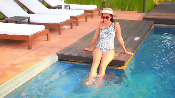 Young asian woman enjoy around outdoor swimming pool for leisure