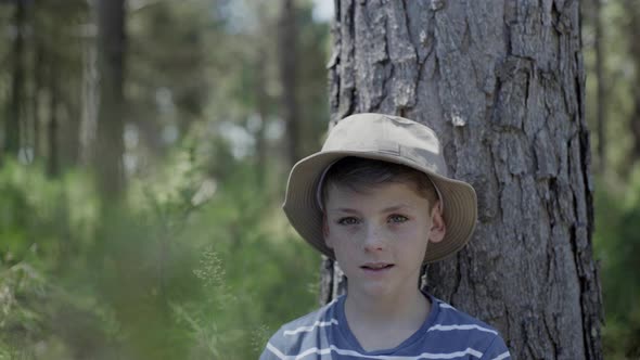Boy leaning against tree trunk, portrait
