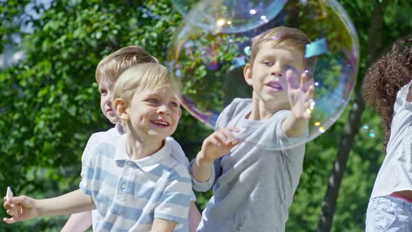 Lovely Children Bursting Large Soap Bubbles