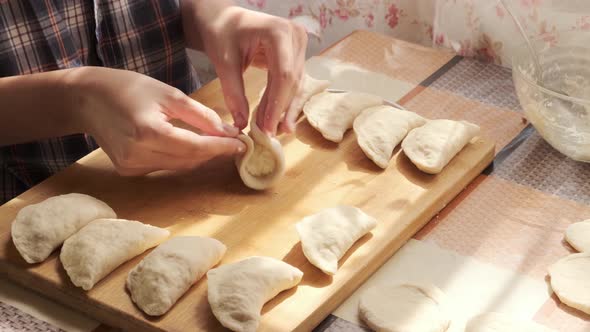 Preparing dumplings. Girl makes home food from dough, hand made dumplings with cottage cheese