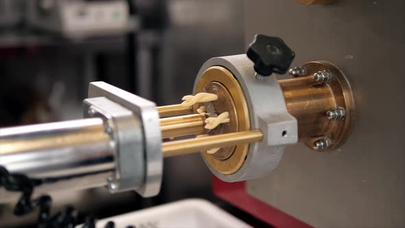 Tortiglioni Cazarece Spaghetti Pasta Falling From a Spout As They Travel Along the Production Line