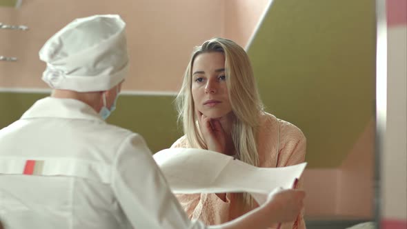 Young Female Doctor with Female Patient Talking in Hospital Room