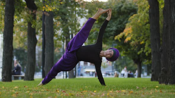 Strong Sportive Islamic Girl in Hijab Yoga Teacher Woman Stands in Side Plank on Grass in Park Doing