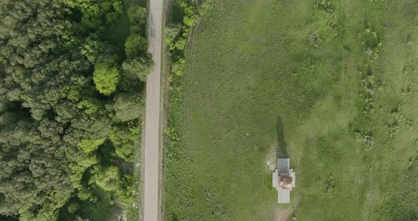 High angle tilt down shot of the Kojori woods, road and the St. George church,