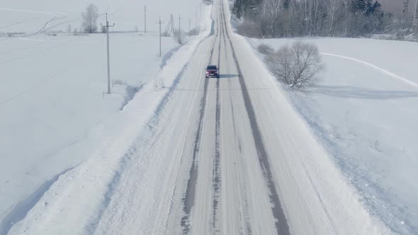 SUV Driving Along the Snow Covered Road in Winter