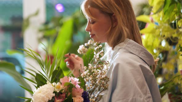 Happy female florist collecting bouquet of flowers