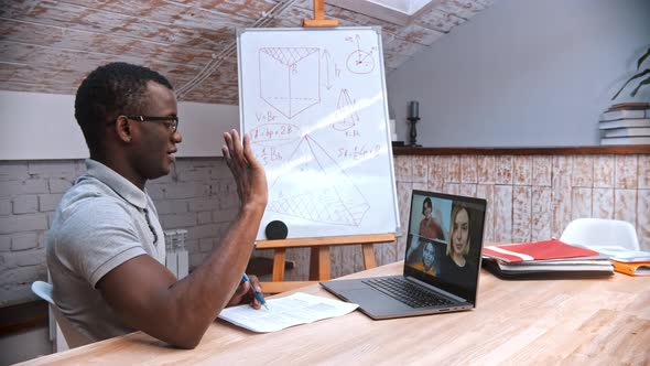 An Online Maths Lesson - an African-american Man Teacher in Glasses Greeting His Students on the