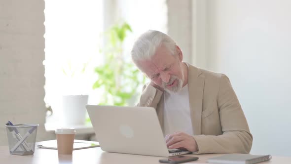 Old Man Having Neck Pain While Using Laptop in Office