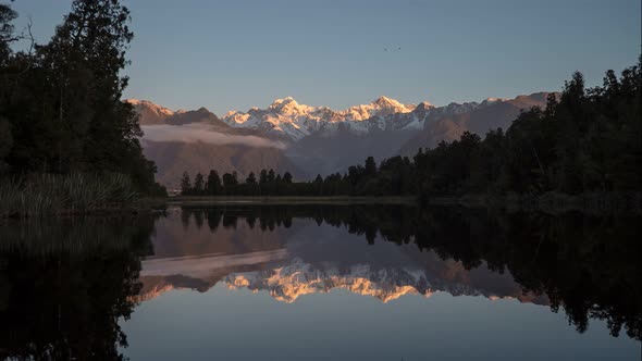 timelapse of the sun setting on mt cook reflected in lake matheson