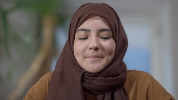 Closeup Portrait of Charming Middle Eastern Young Woman in Hijab with Brown Eyes Looking at Camera