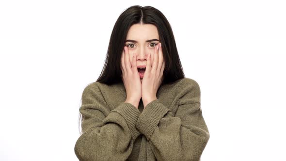 Portrait of Young Thrilled Woman Being Shocked and Covering Open Mouth with Hands in Fear Isolated