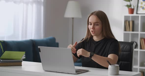 Female Specialist Is Consulting Client By Internet Sitting at Home Sitting in Front of Laptop with