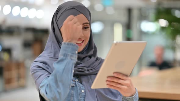 Arab Woman Celebrating Success on Tablet Winning