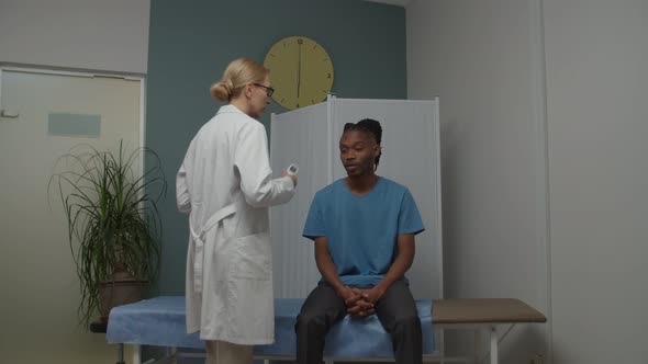 Doctor Measuring Body Temperature with Digital Thermometer Indoors