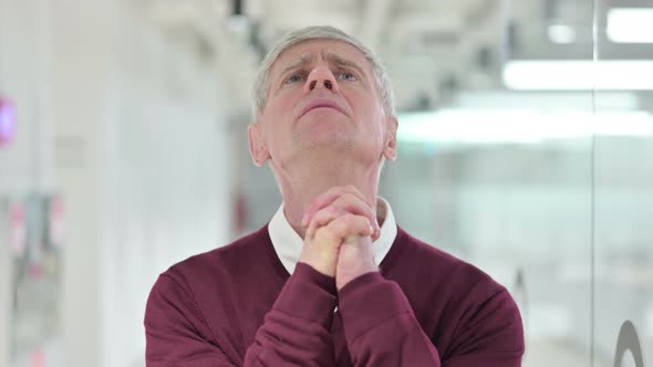 Hopeful Middle Aged Man Praying with Hands Raised 